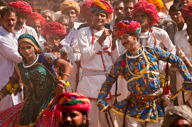 Rajasthani-Volkstänzer in farbenfroher ethnischer Kleidung treten auf dem Viehmarkt in Pushkar auf